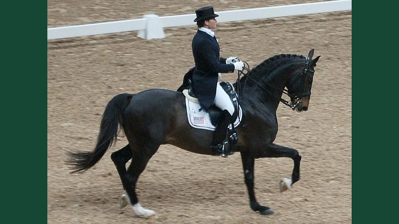 Foto av ett dressyrekipage på tävlingsbana.