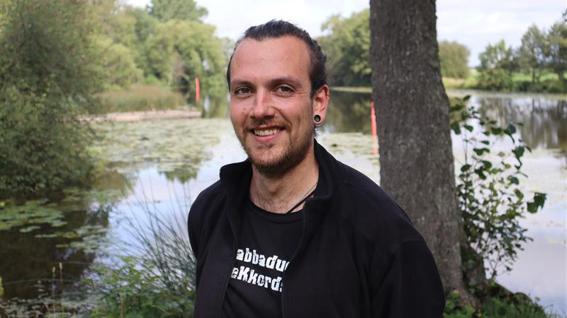 En man framför en sjö. Foto.