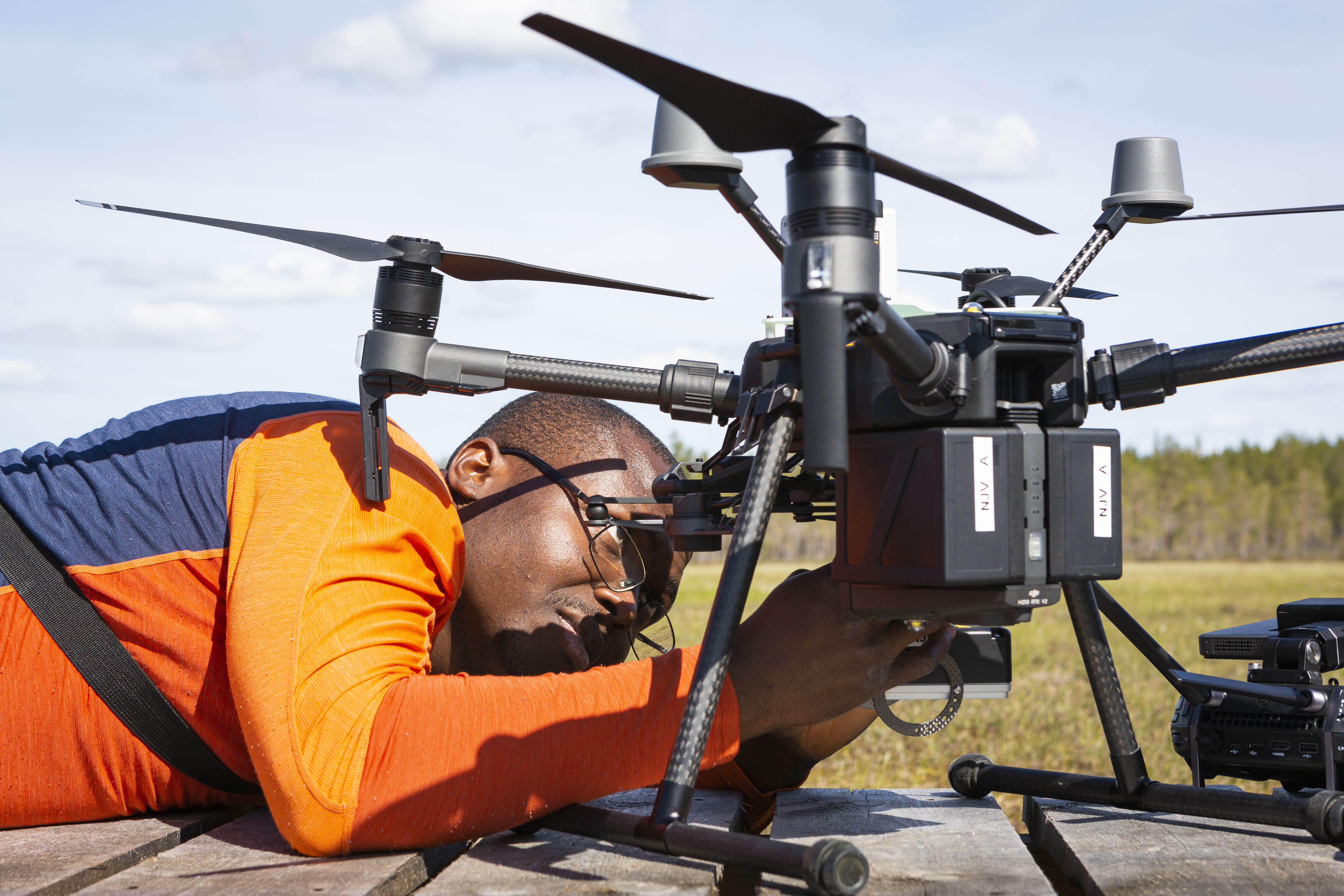 en man ligger ner och tittar på en drönare