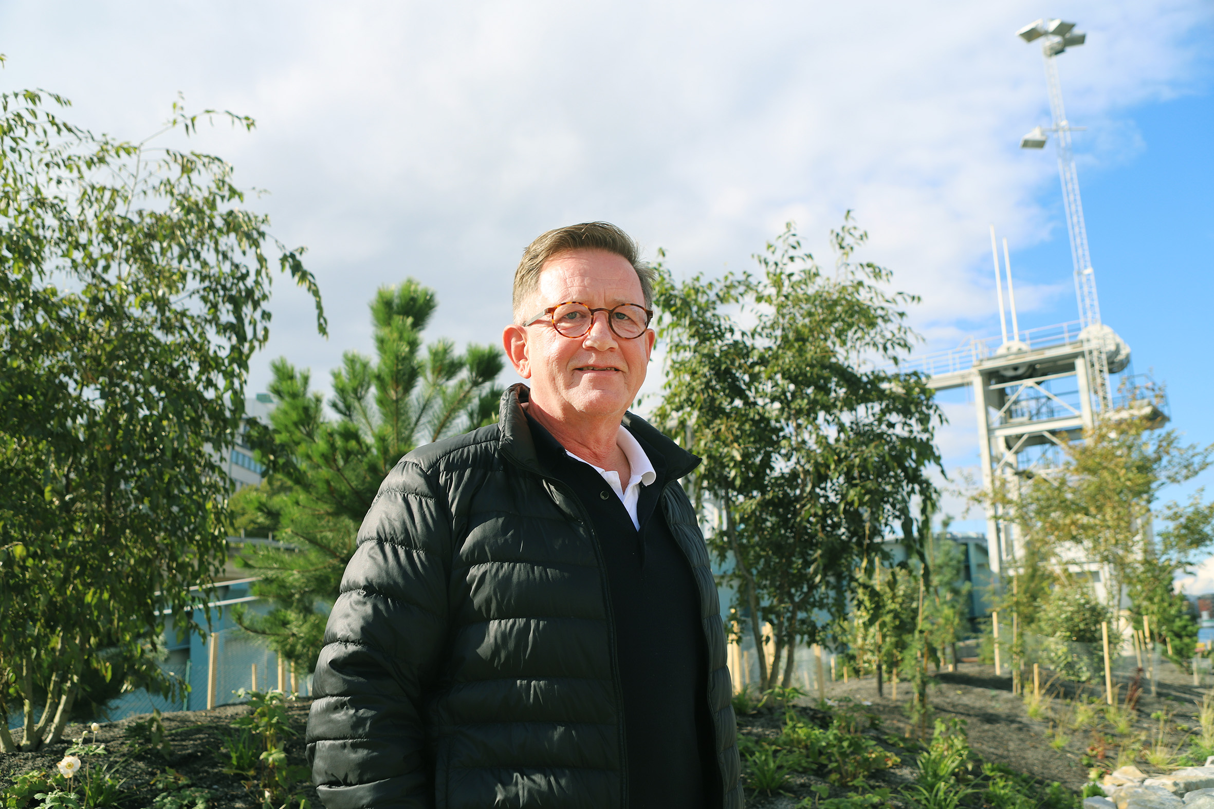 Foto på en man med stadsträd i bakgrunden