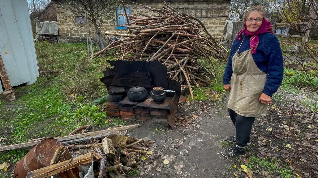 A woman in the village of Borodyanka, southwest of Kyiv, prepares food outside behind the house to go unnoticed. 