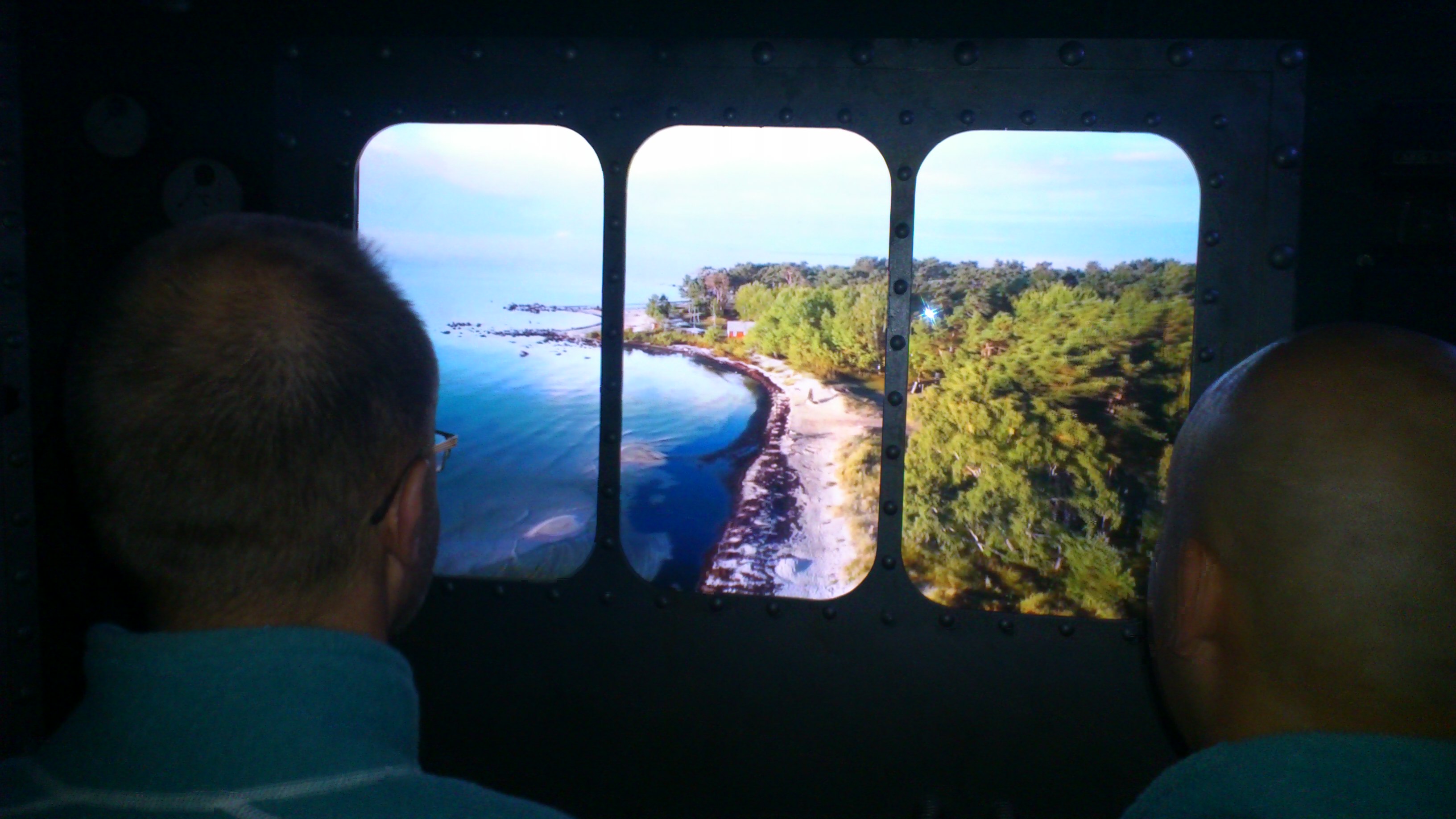 Personer tittar på bilder av hav och skog