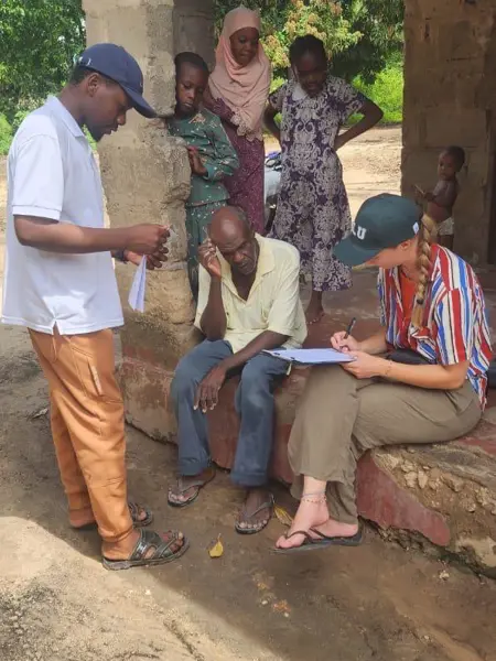 Two persons talking with others in the background
