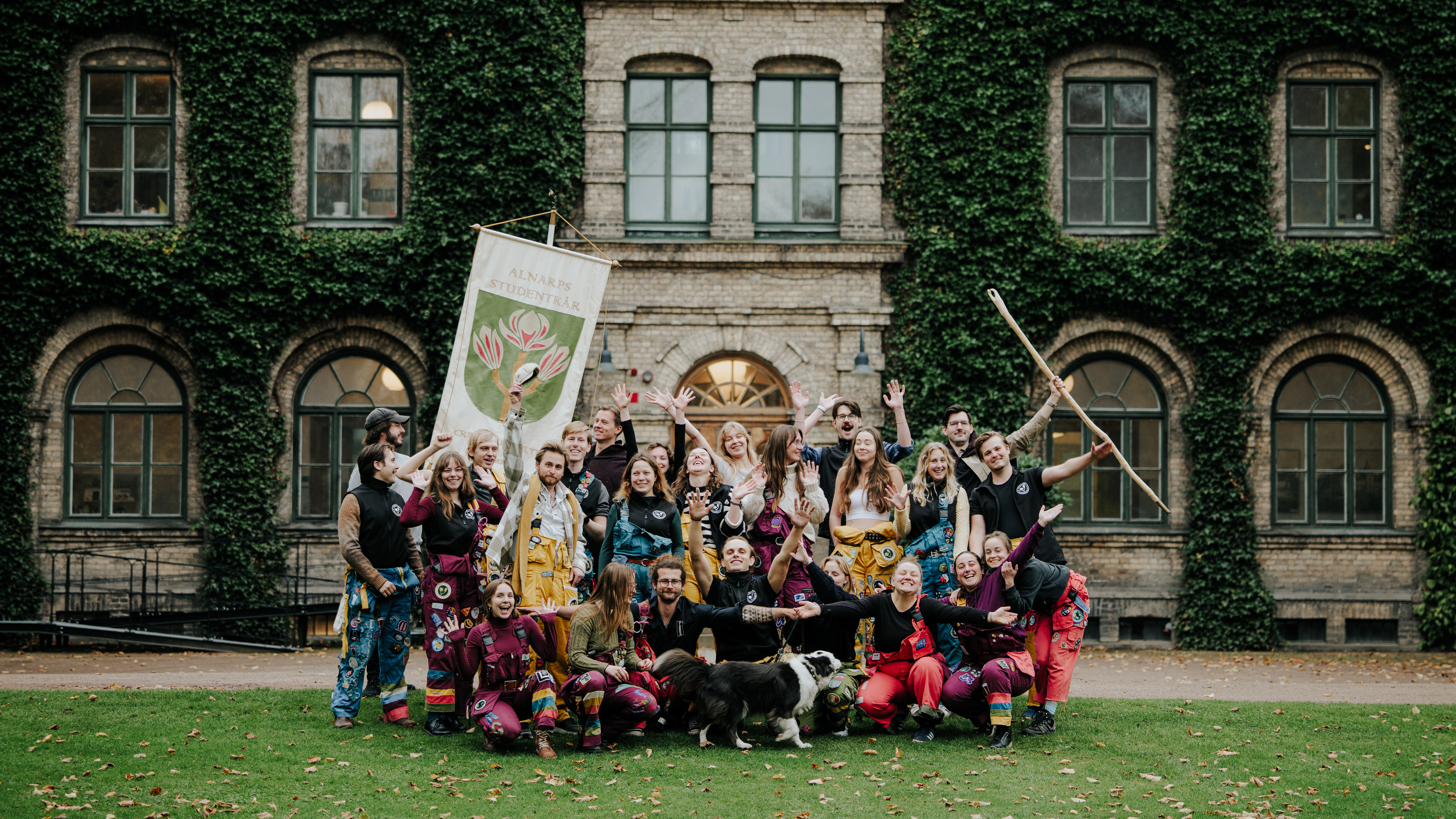 Ett gäng studenter utanför en stenbyggnad.