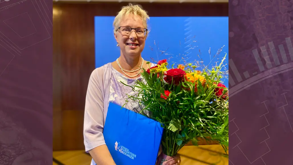 Porträttbild på Lotta Berg med blombukett och pris.