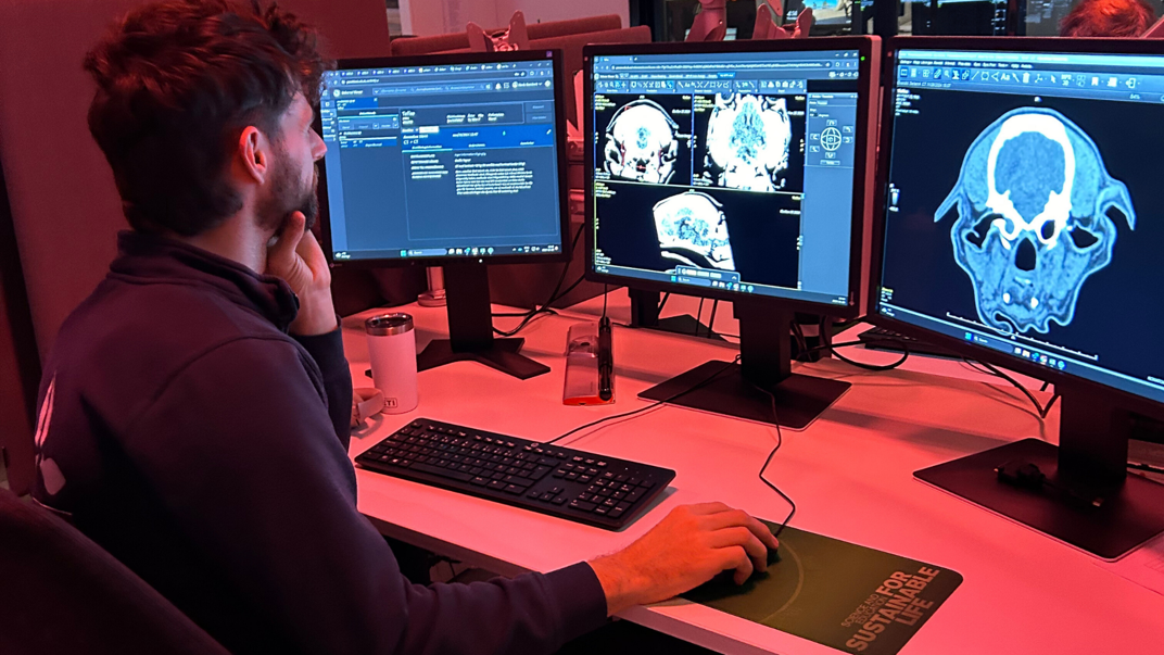 Man sitting in front of computer screens.