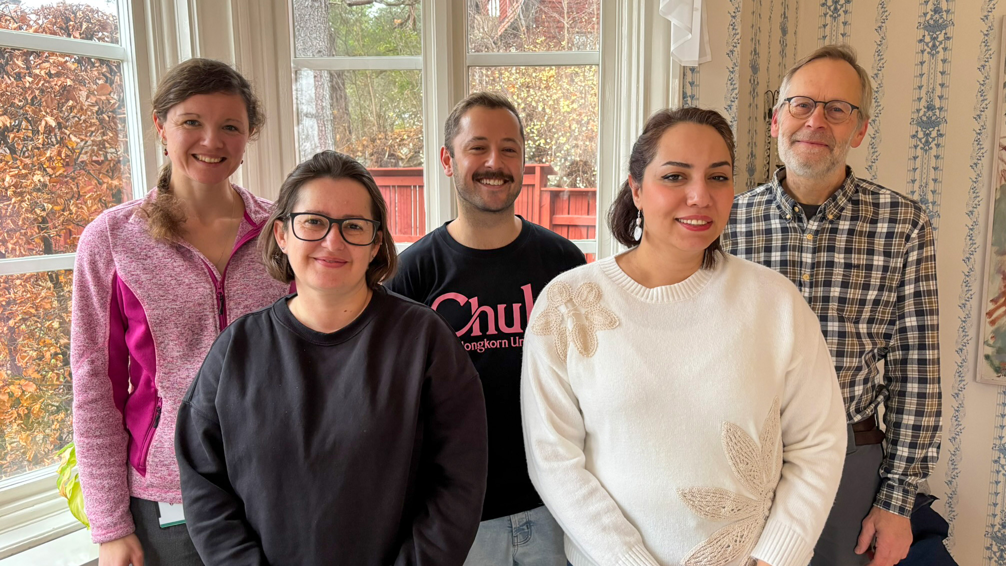 Group photo with five people indoors.