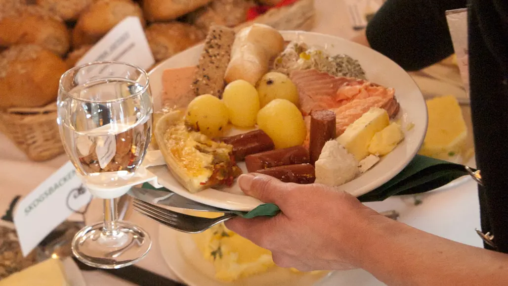 En tallrik med potatis, lax och korv. Foto.