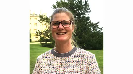 Portrait image of Siobhan Mullan outside, with a building and some trees behind her.