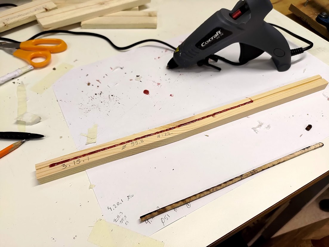 Trästickor limmas ihop på ett arbetsbord.