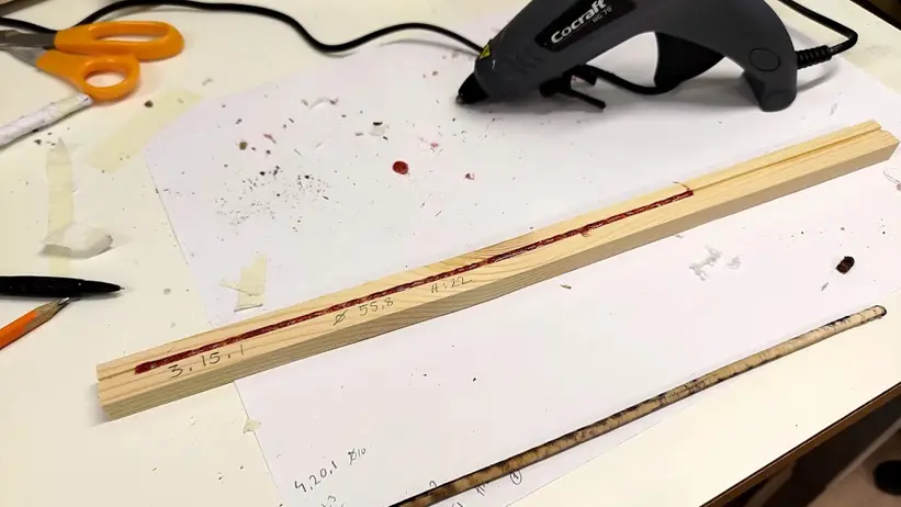 Trästickor limmas ihop på ett arbetsbord.