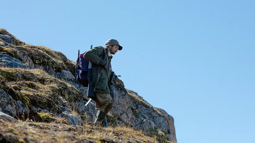 man går ned för klippa