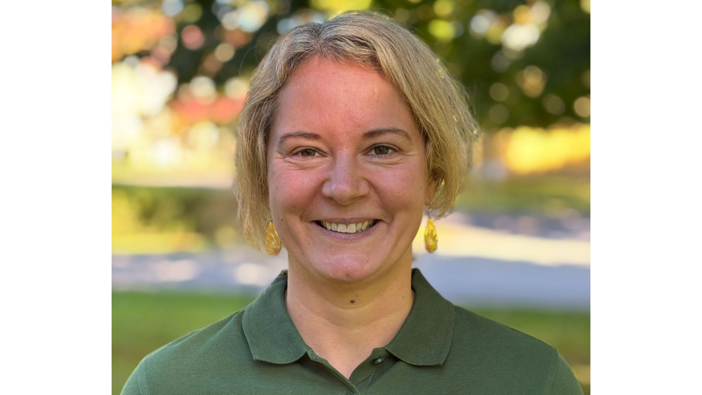 Kvinna med KOrt ljust hår och grön skjorta