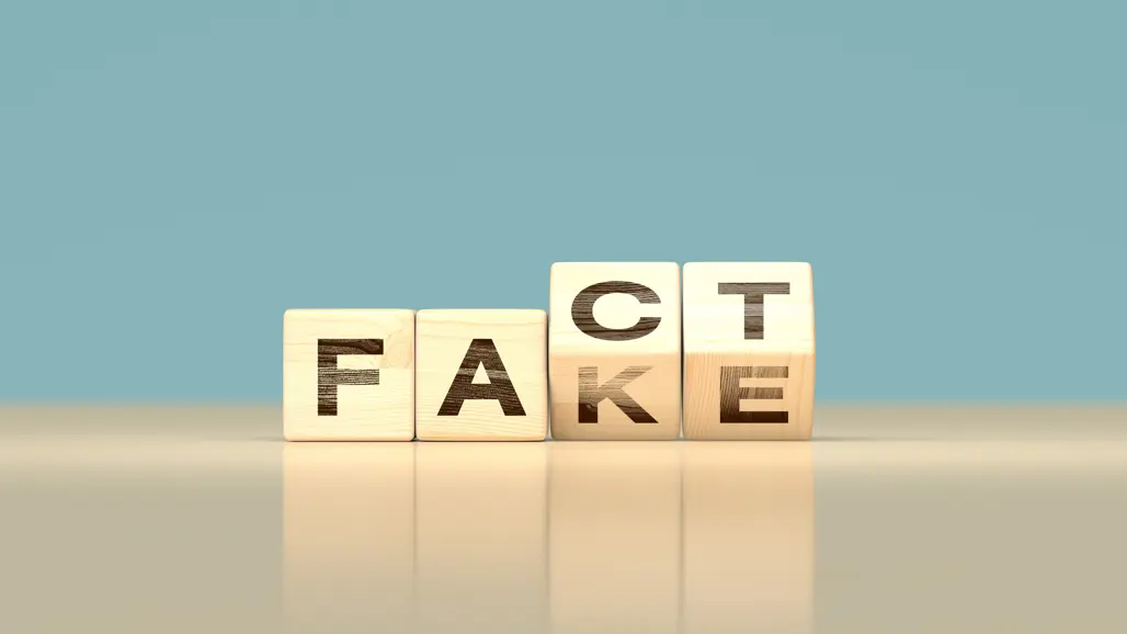 Små kuber med bokstäver visar ordet FACT, men håller på att stuvas om till att bli FAKE istället.