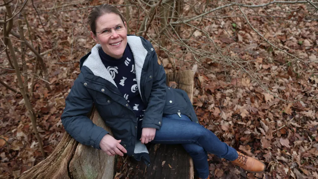 kvinna på en bänk i skogen