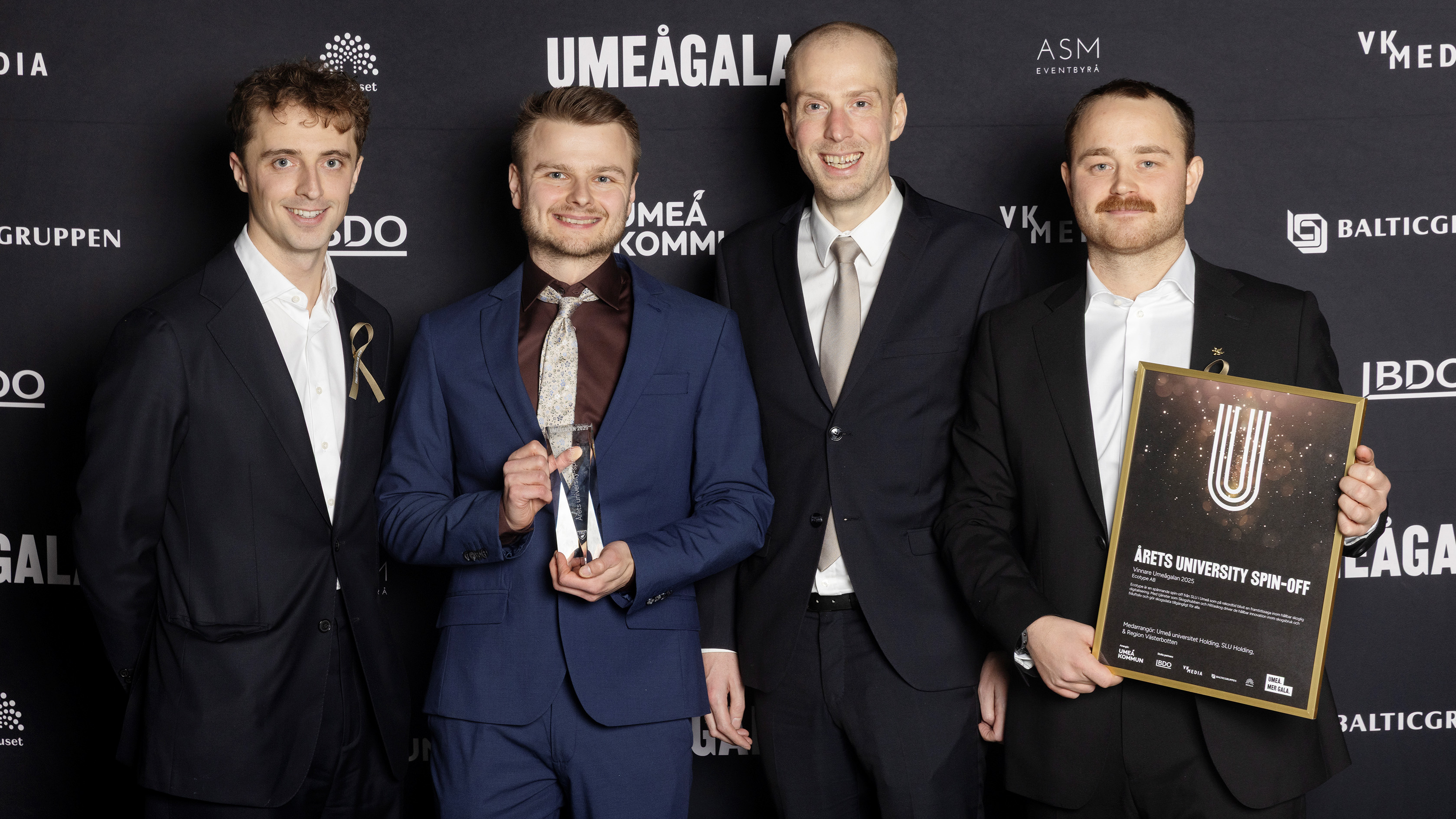 Fyra personer som står bredid varandra.