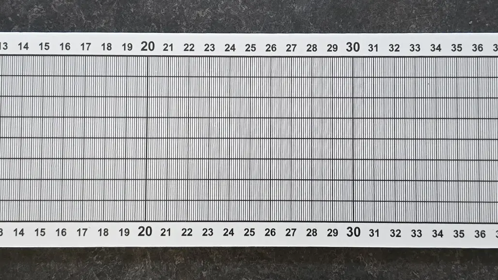 A fish measuring board from SLU, with a white background and black lines for accurate measurements. The board is graduated from 1 to 50 centimeters in both top and bottom, with thin vertical lines for accurate reading. In the upper right corner is the SLU logo and the text Swedish University of Agricultural Sciences, Department of Aquatic Resources.