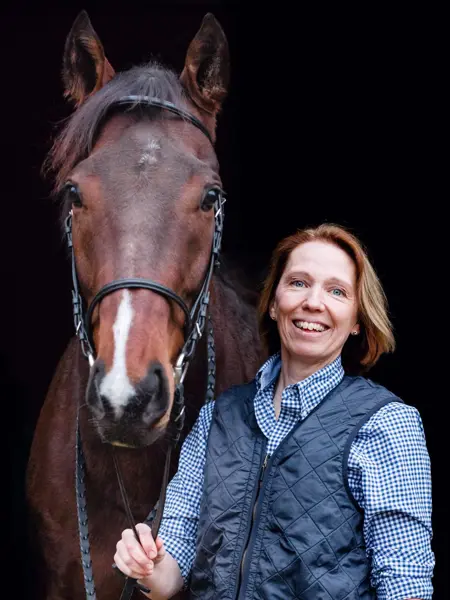Porträtt på Sara Nyman som håller i en häst.