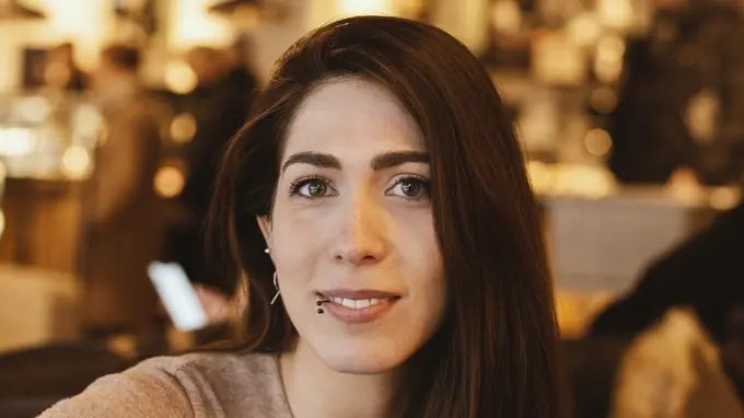 A portrait photo of a woman with dark hair. Photo.