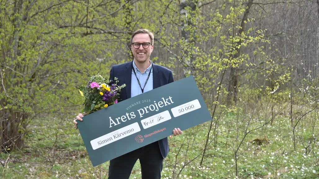 Simon Kärvemo med en prischeck. Foto