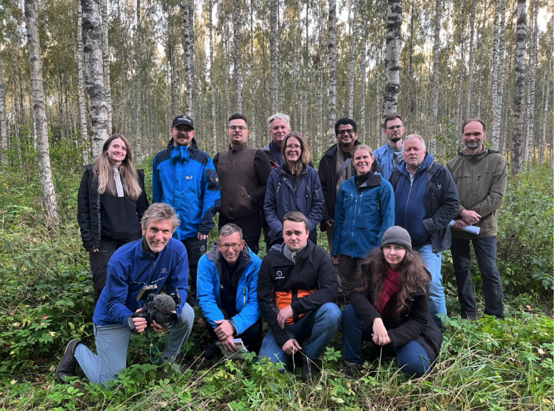 grupp av människor i björkskogen