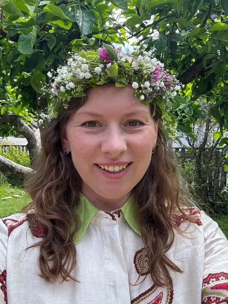 Porträttfoto av en kvinna med en blomsterkrans på huvudet. Foto.