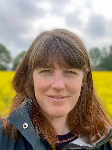 Chloë Raderschal framför ett rapsfält. Foto.