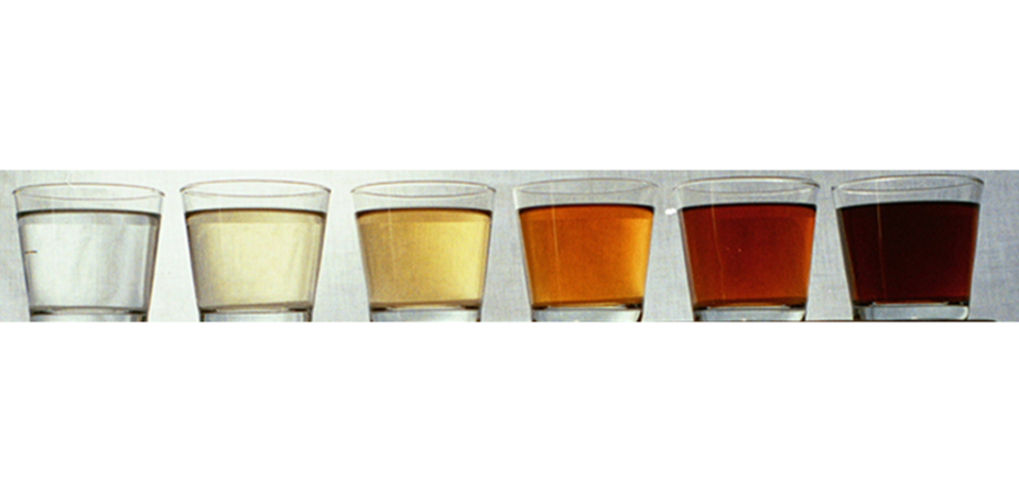 Six glasses of water with water colour ranging from clear to dark brown. Photo.