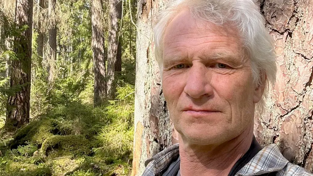 Porträttfoto av en man i skogen.