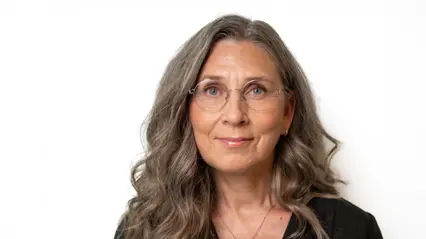 En kvinna med mörkt halvlångt hår och glasögon.