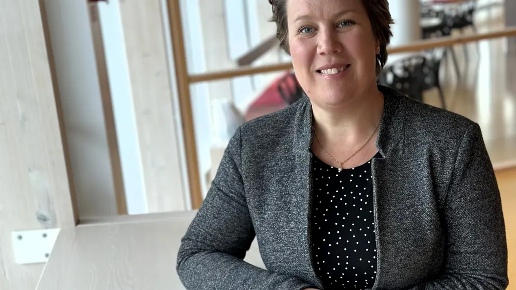 Porträtt av Sara Mangsbo, stående vid ett bord
