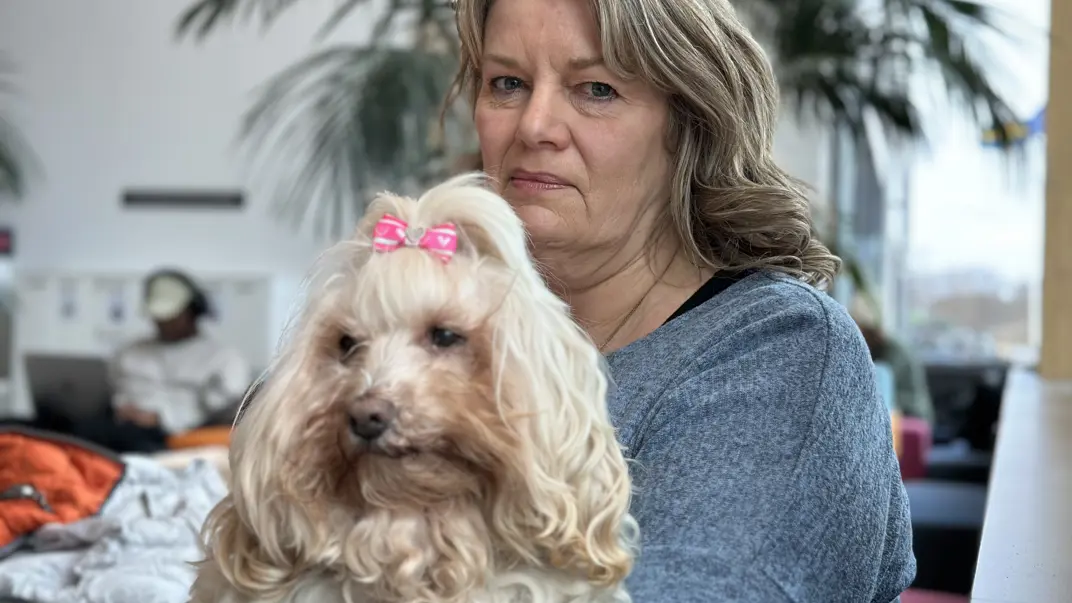 En kvinna sitter med sin hund i knäet