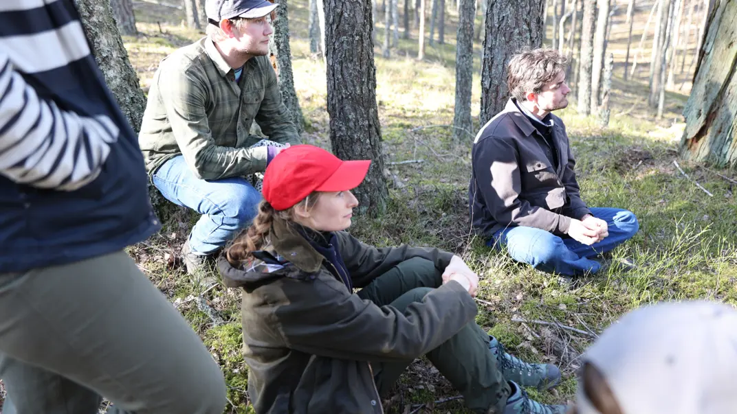 studenter sitter i skogen