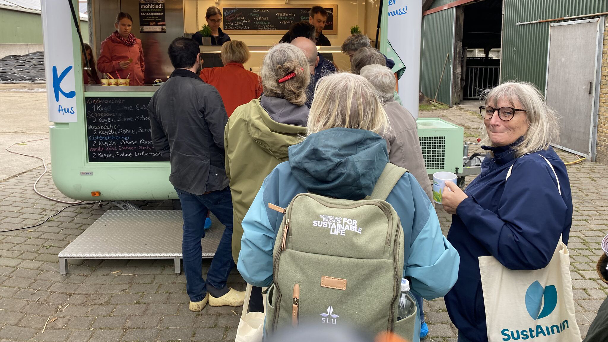Några personer från SLU och SustAinimal köar framför en glasskiosk som säljer gårdsproducerad glass.
