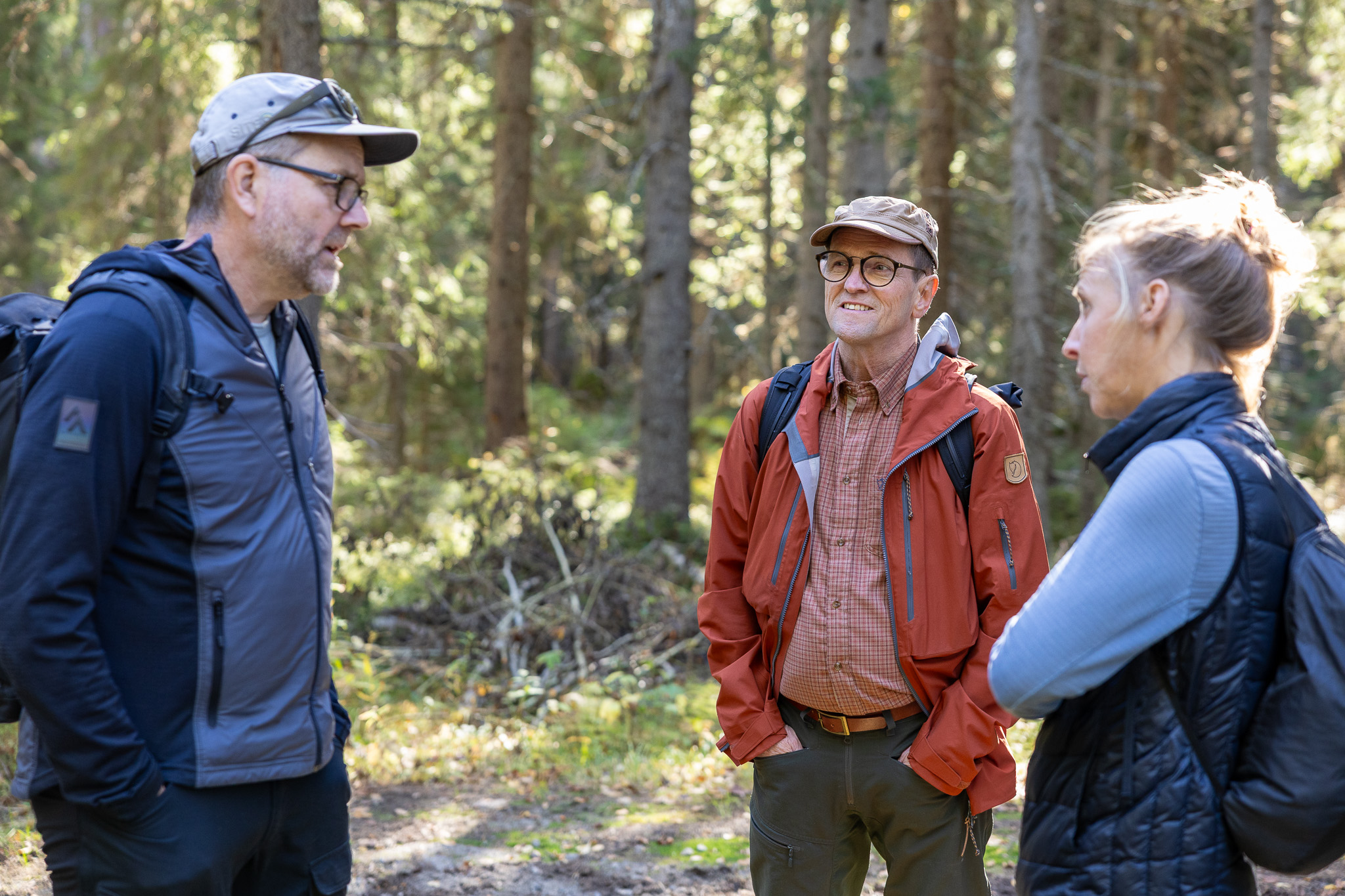 Three people talk to each other during a visit to the forest.