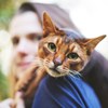 Bild av en kvinna med en katt sittande på axeln.