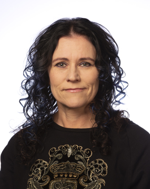 Porträttbild av kvinna med svart, lockigt hår. Foto.