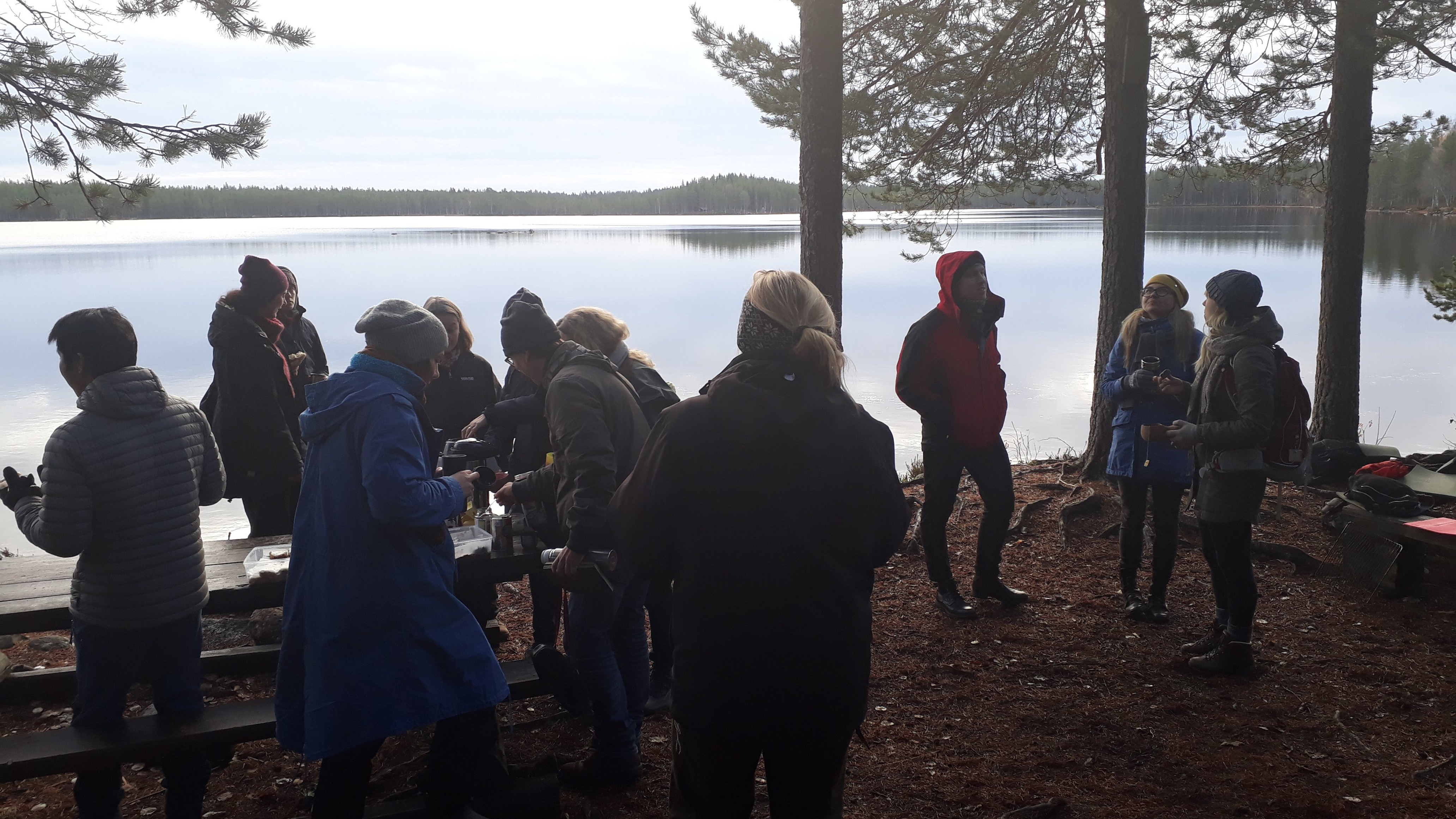 Mäniskor i siluett vid spegelblank sjö