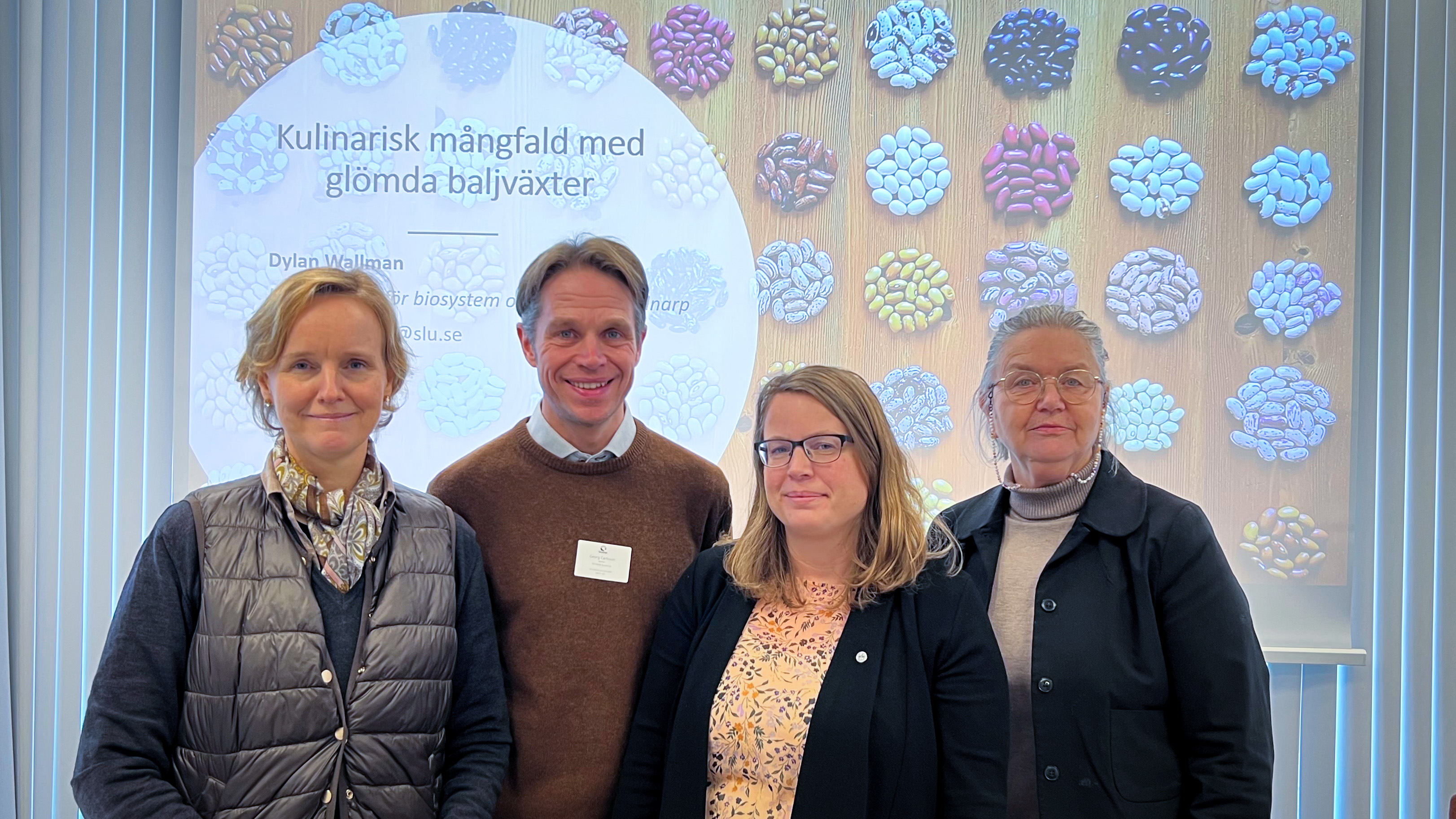 Fyra personer framför en presentation med många olika sorters bönor