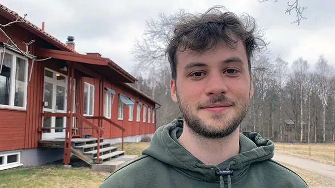 Ansikte på en ung man med kort, mörkt hår. Foto.