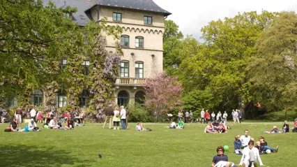Park environment with people and a castle building in the background. Photo: Jenny Svennås-Gillner