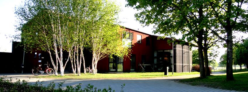 Building surrounded by trees in a green park setting.