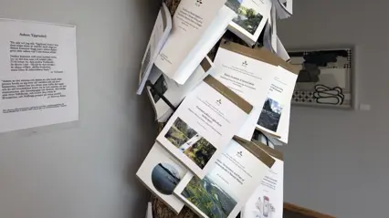 Dissertations nailed on tree trunk indoors. Photo.