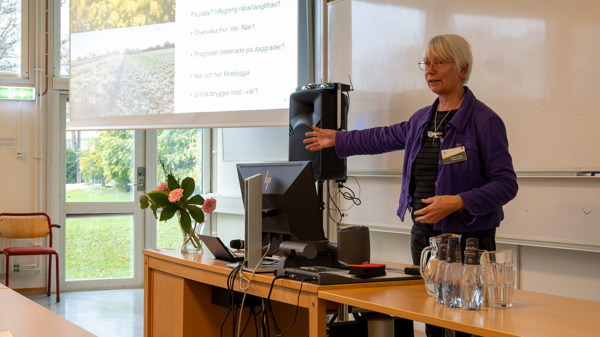 En kvinna talar framför publik. Foto.