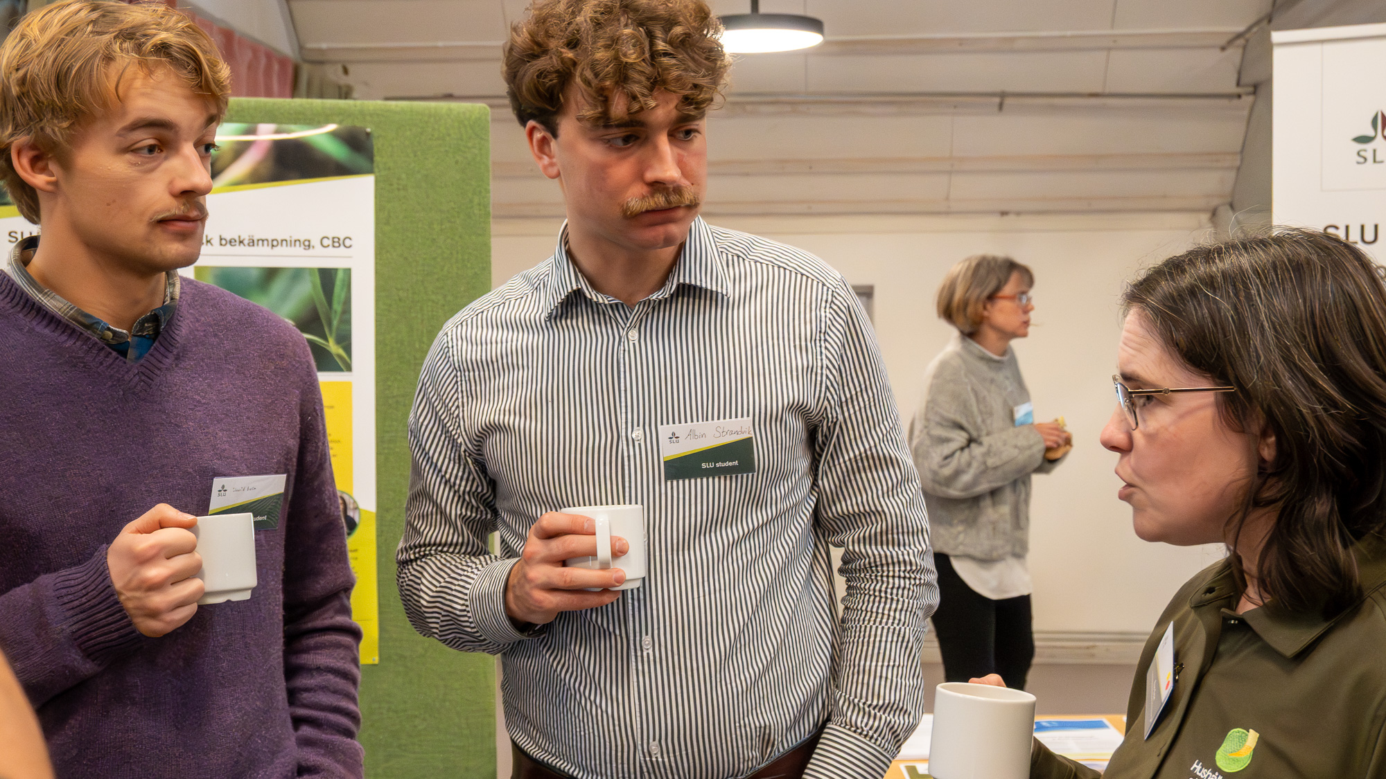 Två män pratar med en kvinna. Foto.