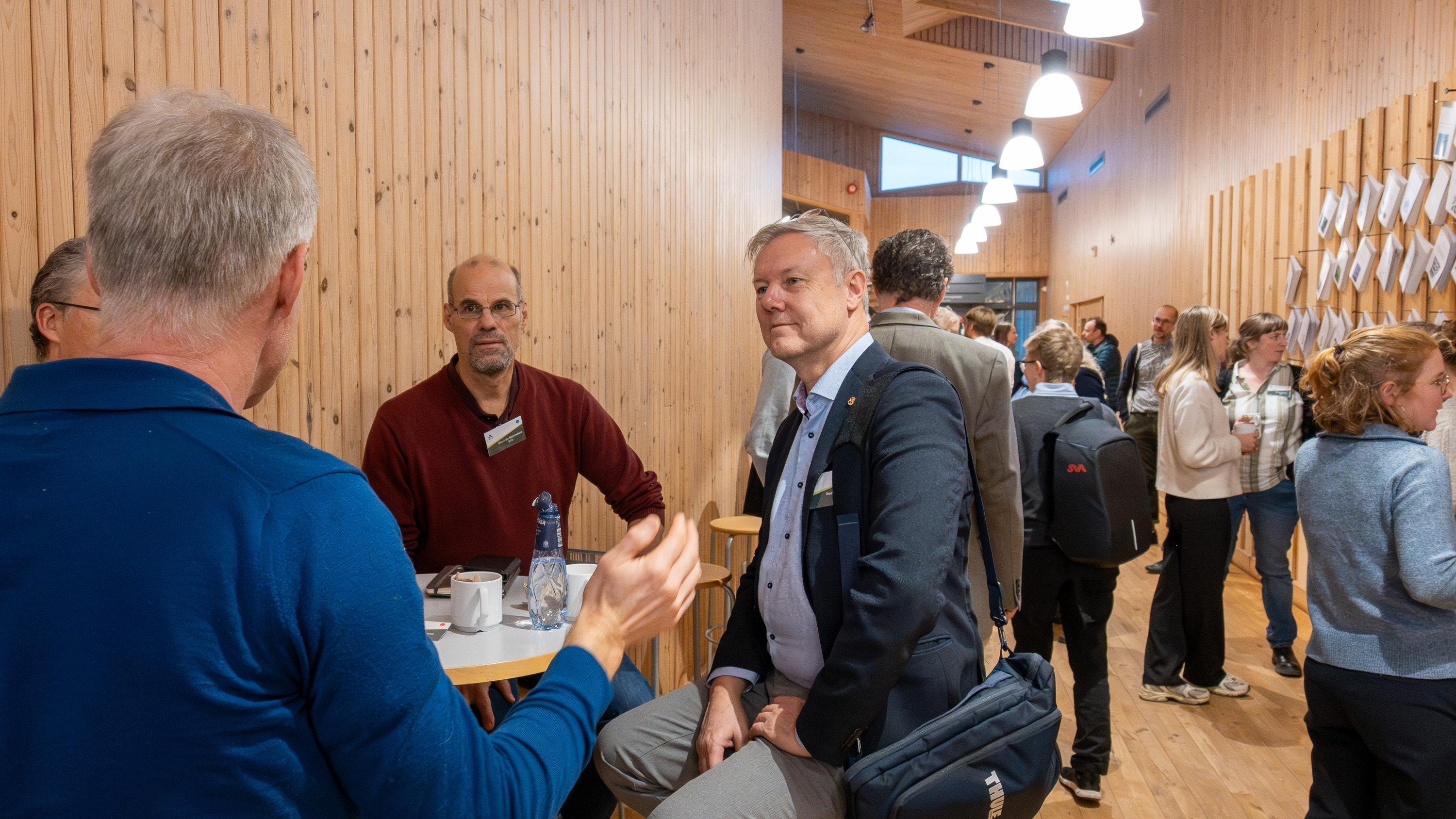 Tre personer runt ett bord. Foto.