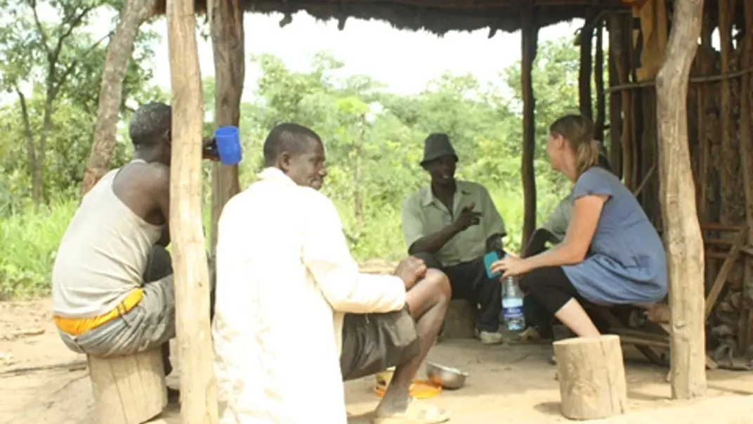 A group of people sitting outside discussing.