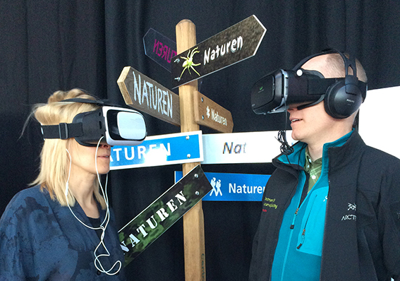 Två personer med VR-glasögon och skyltar med texten Naturen
