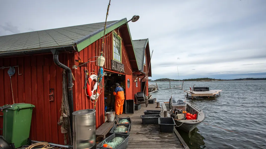 Motorboat with fishing nets outside a boathouse