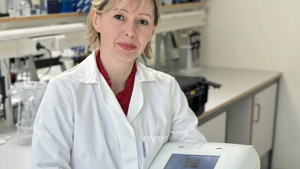 kvinna i labrock med en maskin